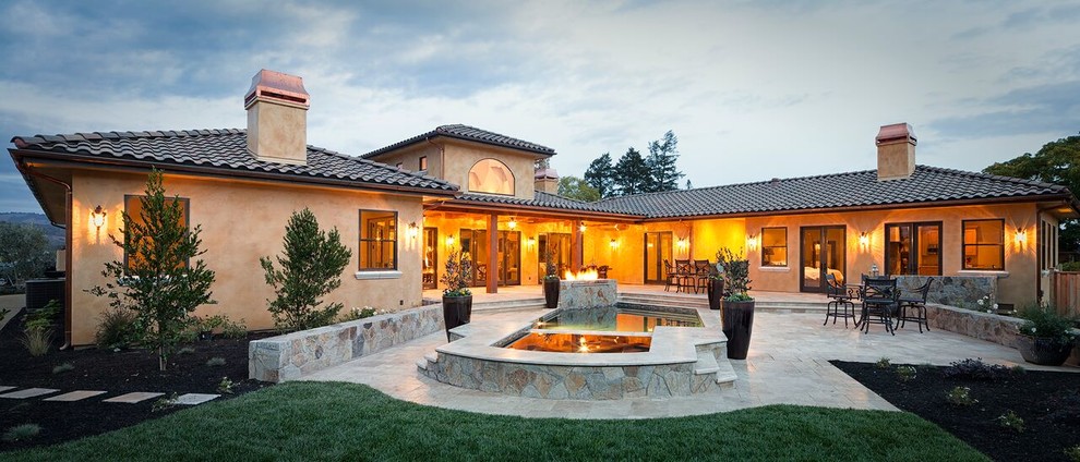 Photo of an expansive mediterranean backyard patio in San Francisco with a water feature, natural stone pavers and a roof extension.