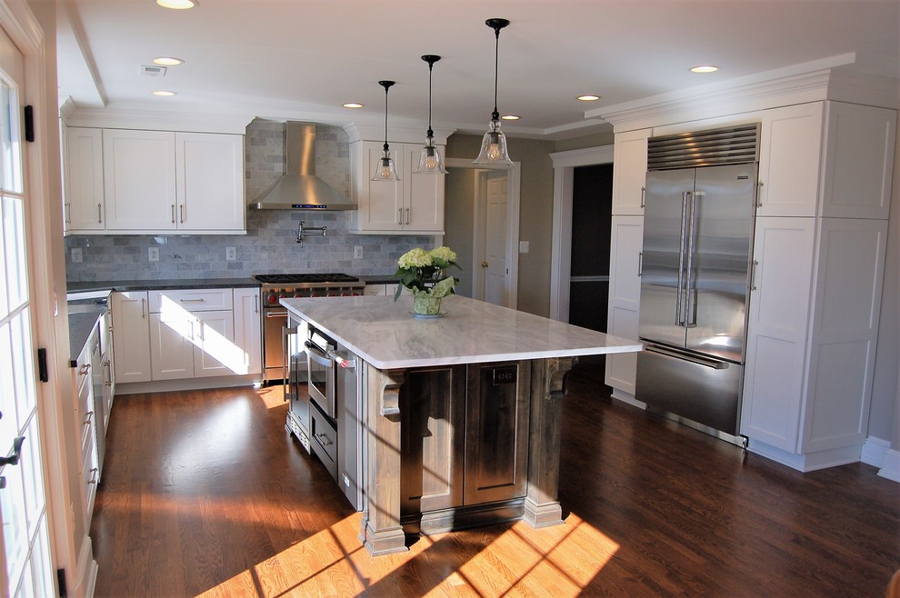 Inspiration for a large transitional u-shaped medium tone wood floor eat-in kitchen remodel in Baltimore with an undermount sink, shaker cabinets, white cabinets, marble countertops, gray backsplash, ceramic backsplash, stainless steel appliances and an island