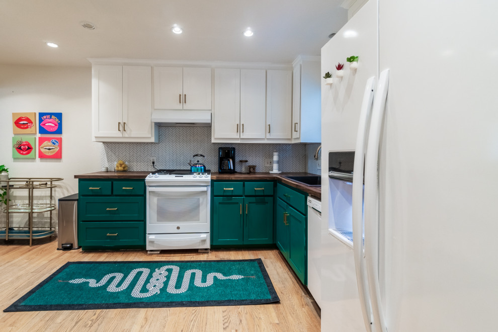 Mid-sized eclectic l-shaped eat-in kitchen in Dallas with a drop-in sink, recessed-panel cabinets, green cabinets, wood benchtops, white splashback, ceramic splashback, white appliances, medium hardwood floors, no island, brown floor and brown benchtop.