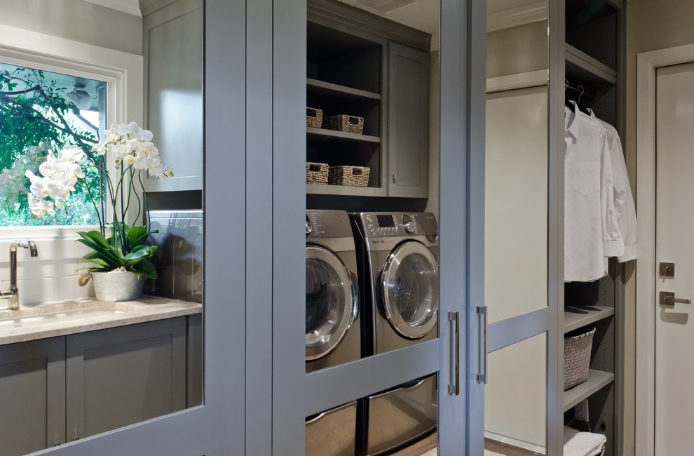 Mid-sized transitional galley dedicated laundry room in Austin with an undermount sink, shaker cabinets, grey cabinets, marble benchtops, grey walls, a side-by-side washer and dryer and medium hardwood floors.