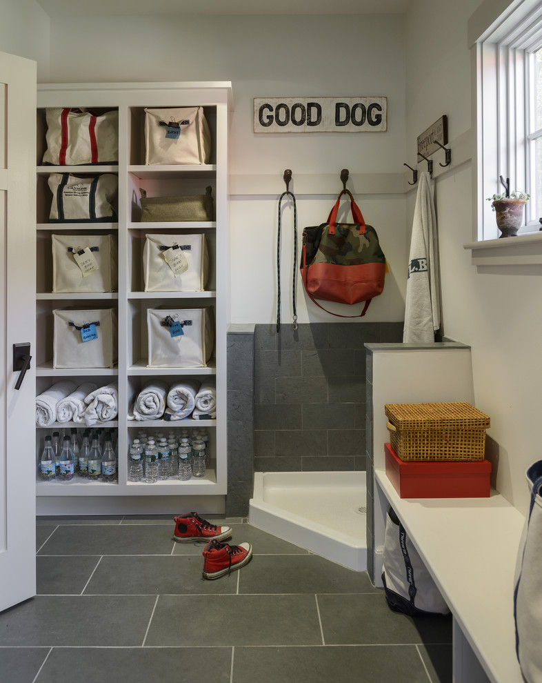 This is an example of a mid-sized traditional mudroom in Portland Maine with a single front door, white walls and slate floors.