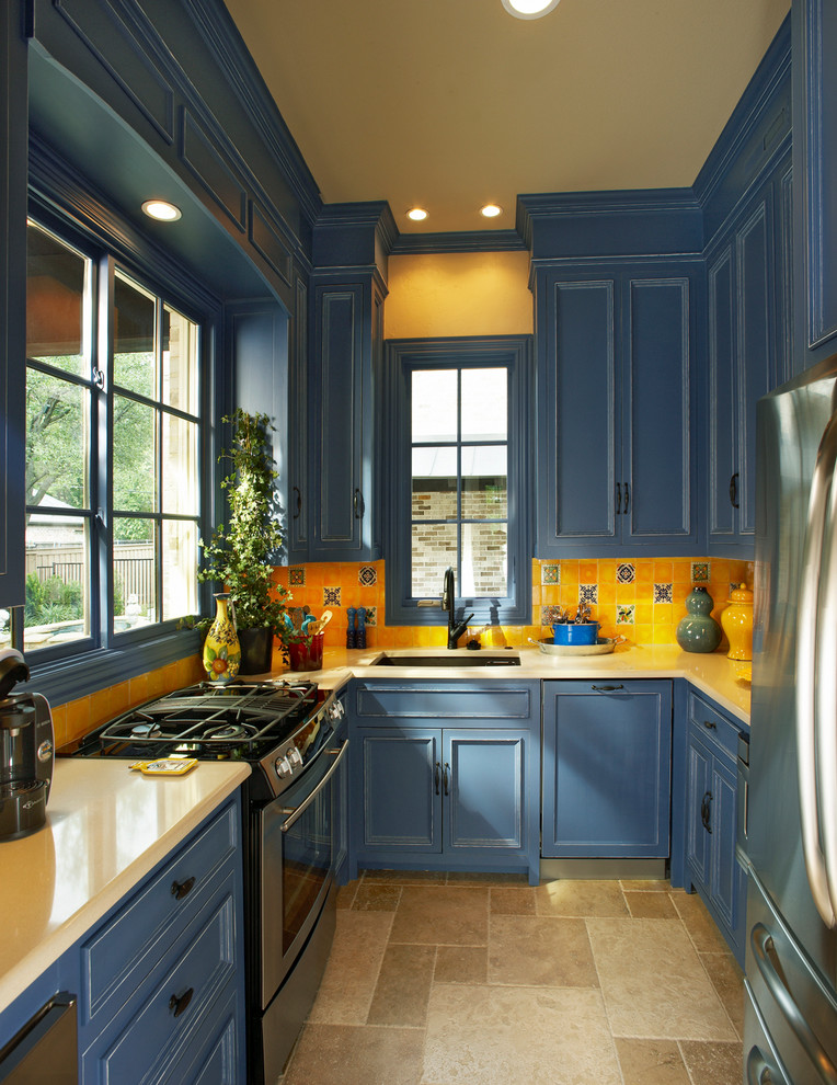 Photo of a traditional u-shaped separate kitchen in Dallas with an undermount sink, recessed-panel cabinets, blue cabinets, yellow splashback, ceramic splashback, stainless steel appliances and yellow benchtop.