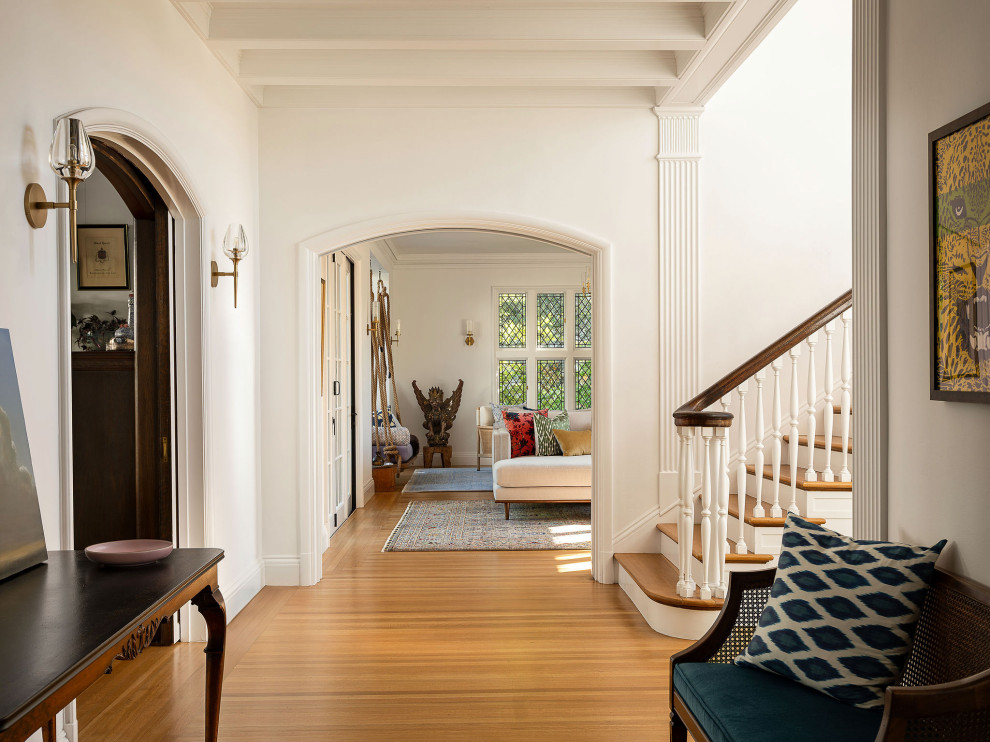 Large transitional medium tone wood floor and brown floor foyer photo in San Francisco with white walls and a dark wood front door