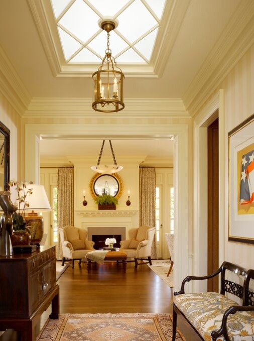 Inspiration for a mid-sized traditional hallway with beige walls, light hardwood floors and brown floor.