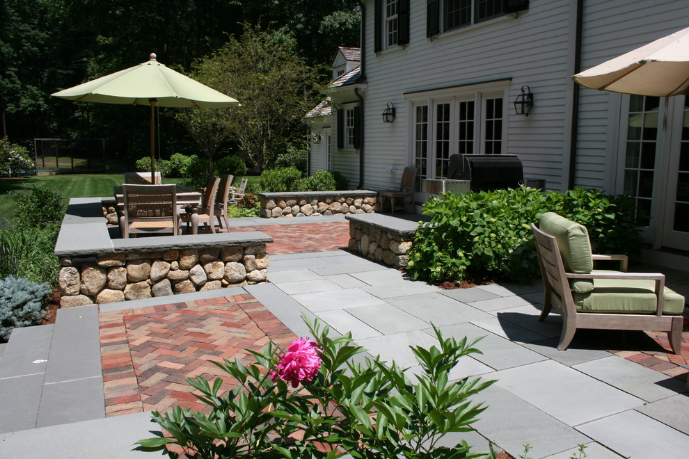 Inspiration for a large traditional backyard patio in Boston with a fire feature and natural stone pavers.