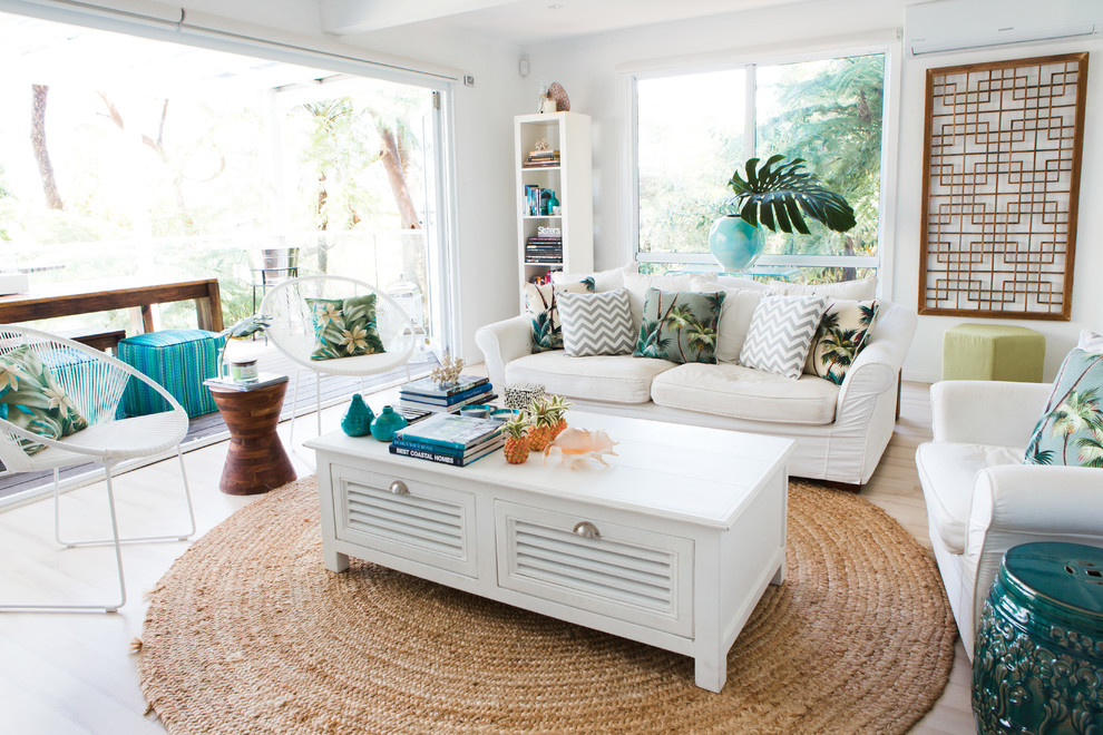 Mid-sized beach style open concept living room in Sydney with white walls and light hardwood floors.