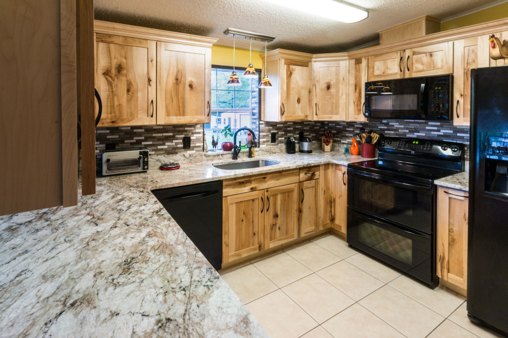 Mid-sized u-shaped cement tile floor and beige floor eat-in kitchen photo with an undermount sink, shaker cabinets, light wood cabinets, granite countertops, glass tile backsplash, black appliances, a peninsula and beige countertops