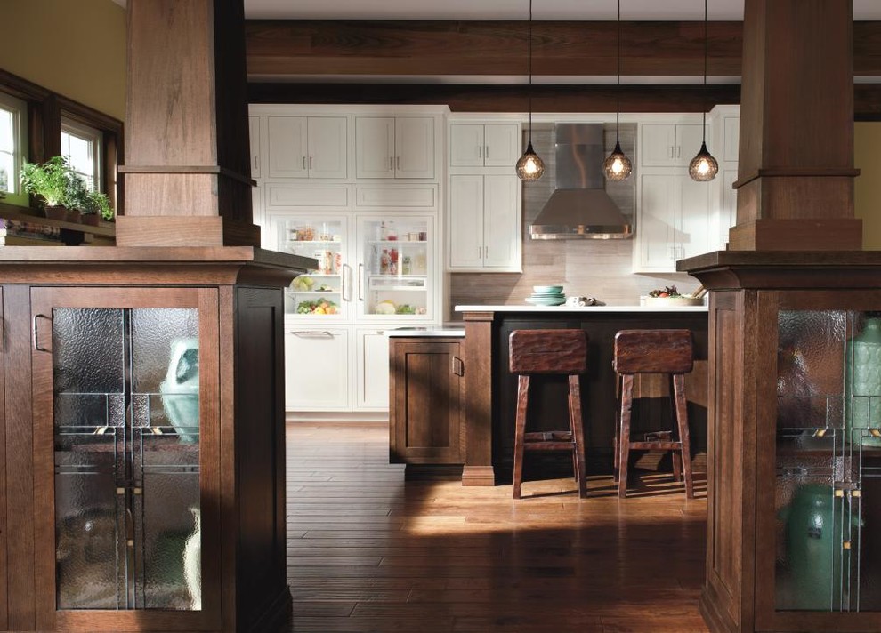 Large mountain style l-shaped medium tone wood floor eat-in kitchen photo with a farmhouse sink, shaker cabinets, white cabinets, stainless steel appliances, yellow walls and an island