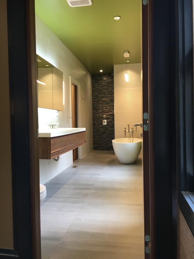 Photo of a mid-sized asian master bathroom in Atlanta with open cabinets, medium wood cabinets, a freestanding tub, an open shower, a two-piece toilet, grey walls, concrete floors and a wall-mount sink.