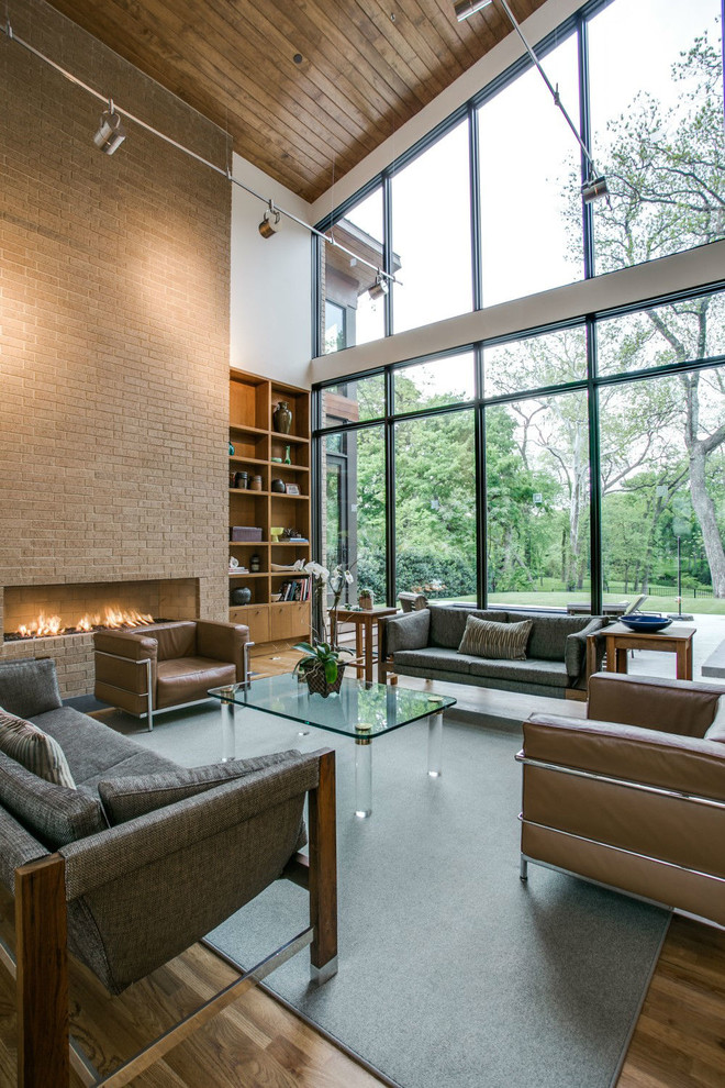 Large contemporary open concept living room in Dallas with white walls, light hardwood floors, a ribbon fireplace and a brick fireplace surround.