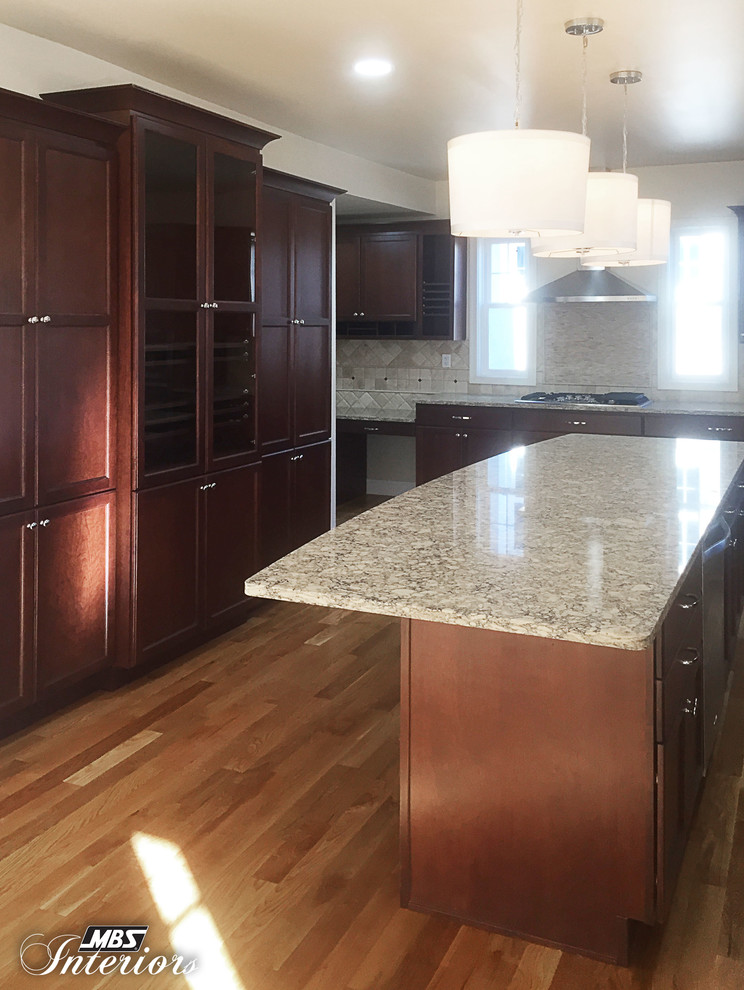 Large transitional medium tone wood floor eat-in kitchen photo in Cincinnati with an undermount sink, recessed-panel cabinets, dark wood cabinets, quartz countertops, beige backsplash, stone tile backsplash, stainless steel appliances and an island