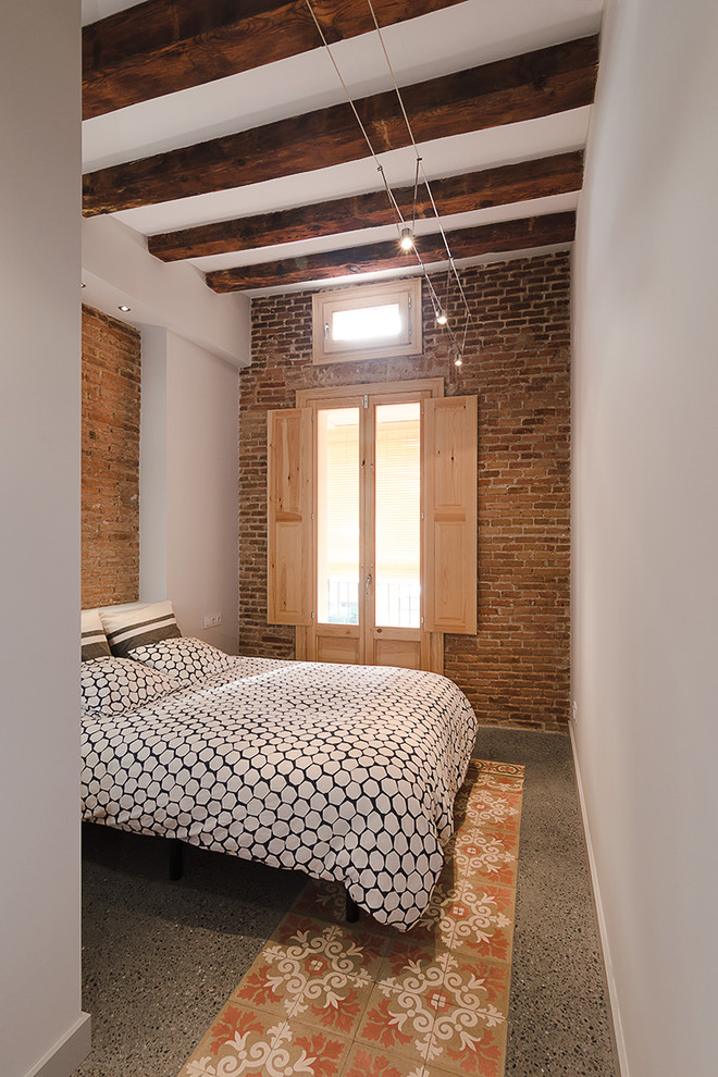 Photo of an industrial master bedroom in Barcelona with white walls and concrete floors.