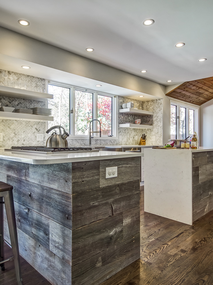 Inspiration for a transitional dark wood floor kitchen remodel in Denver with a farmhouse sink, shaker cabinets, white cabinets, quartz countertops, stone tile backsplash and an island