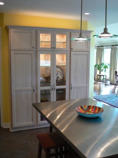 Inspiration for a mid-sized modern u-shaped kitchen pantry in Austin with shaker cabinets, light wood cabinets, stainless steel benchtops, vinyl floors and with island.