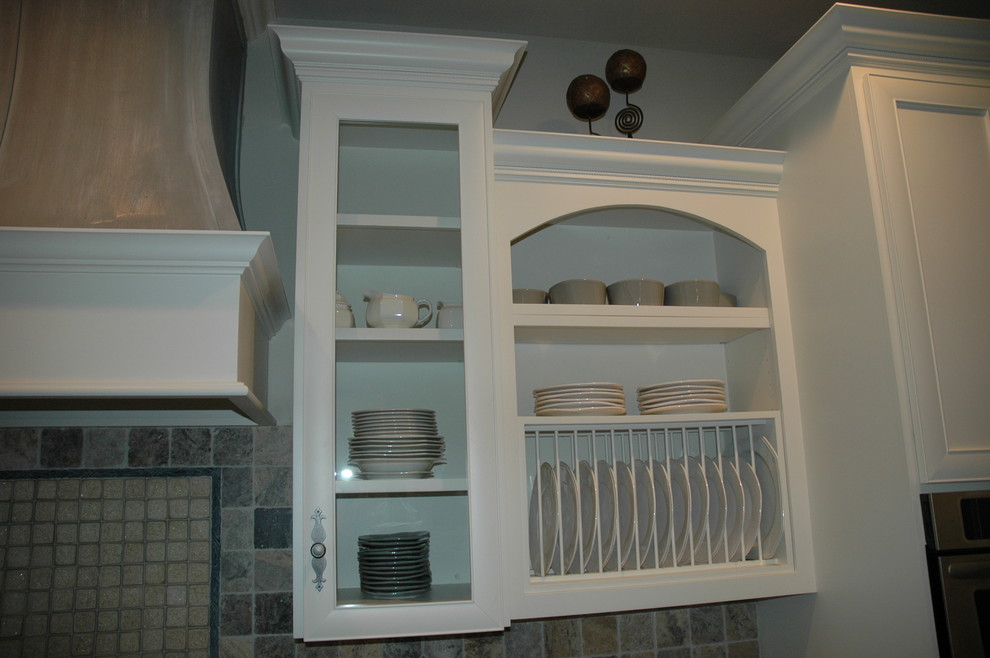 Inspiration for a large transitional u-shaped medium tone wood floor kitchen pantry remodel with a farmhouse sink, flat-panel cabinets, yellow cabinets, laminate countertops, brown backsplash, stone tile backsplash, paneled appliances and an island