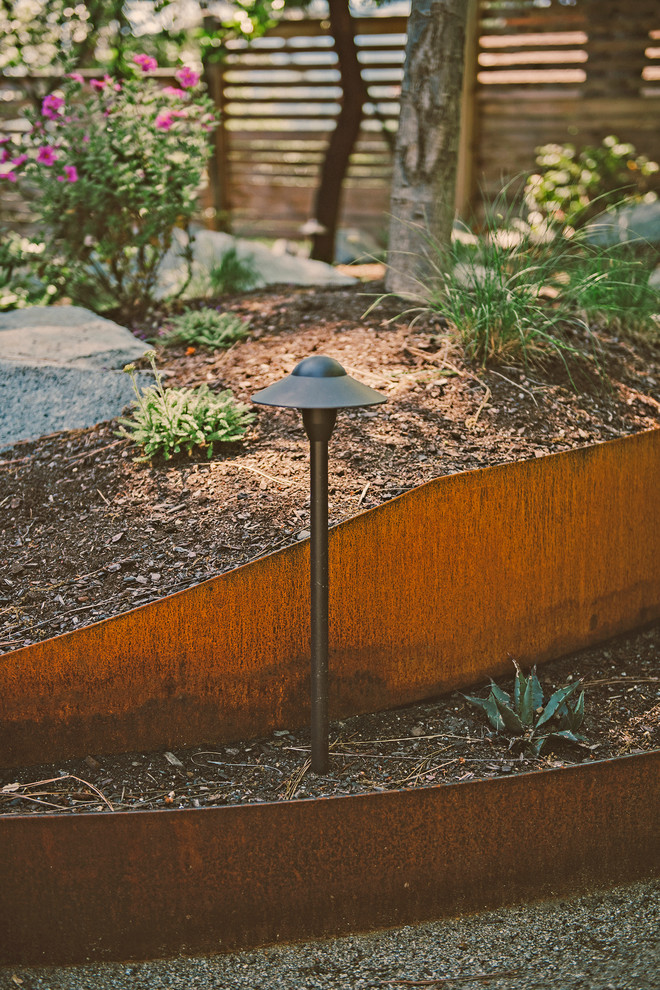 Photo of a mid-sized rustic drought-tolerant and partial sun backyard mulch landscaping for summer.