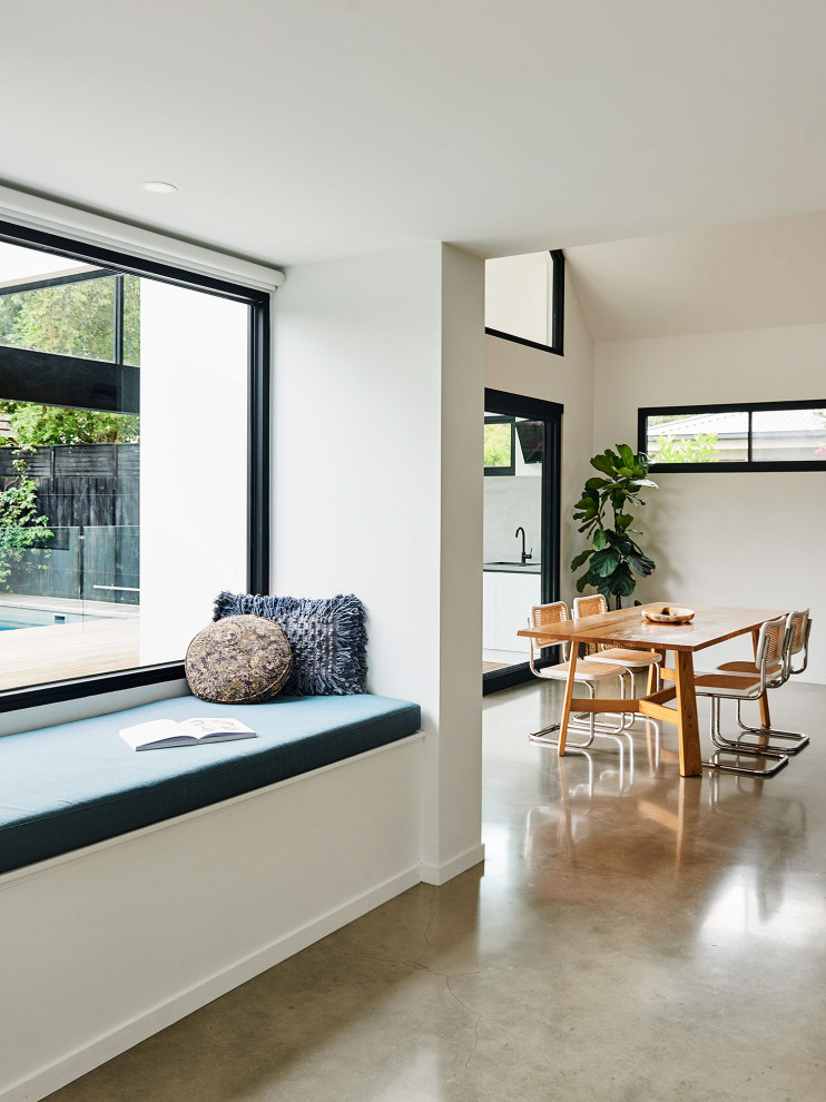Diseño de comedor abovedado tropical de tamaño medio con suelo de cemento, suelo gris y paredes blancas