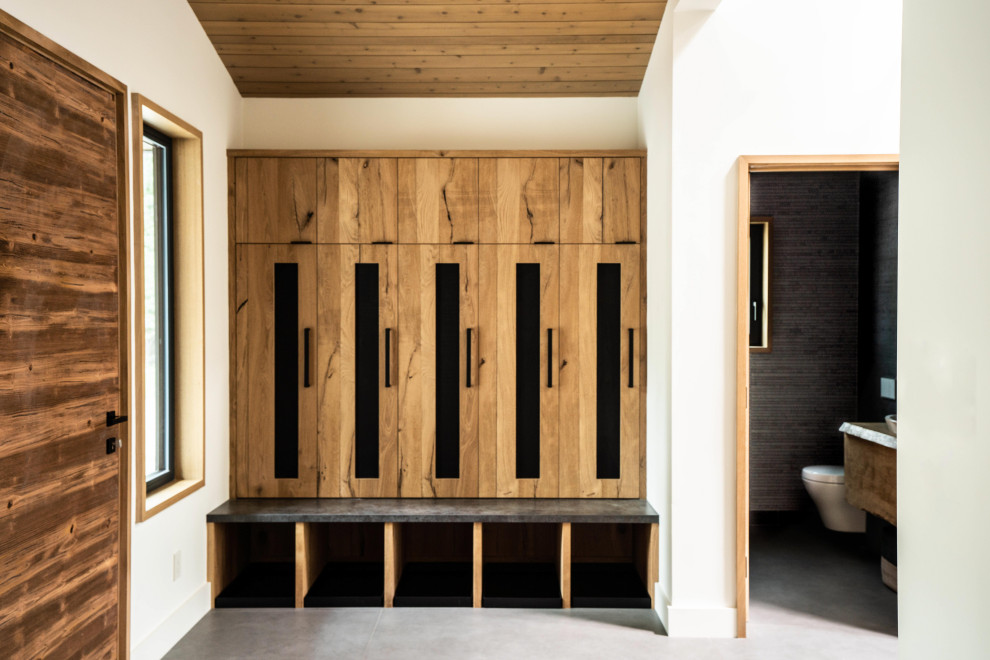 На фото: тамбур среднего размера в современном стиле с одностворчатой входной дверью, серым полом и деревянным потолком с