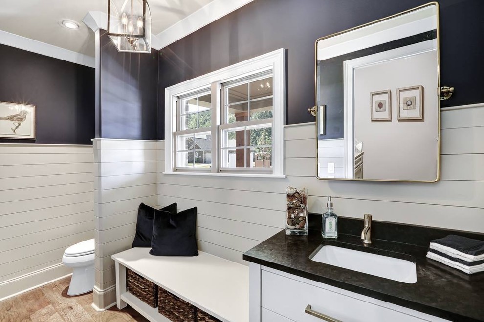 Photo of a mid-sized country 3/4 bathroom in Other with flat-panel cabinets, white cabinets, a two-piece toilet, white tile, blue walls, medium hardwood floors, an undermount sink, engineered quartz benchtops and brown floor.
