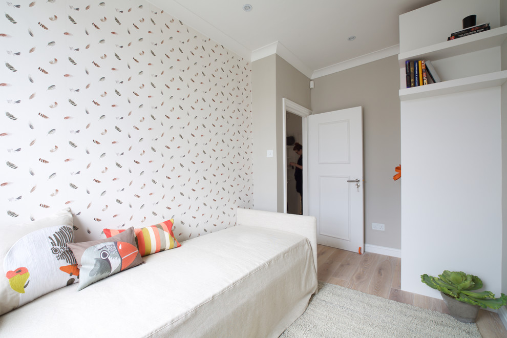 Inspiration for a small contemporary guest bedroom in London with beige walls and light hardwood floors.