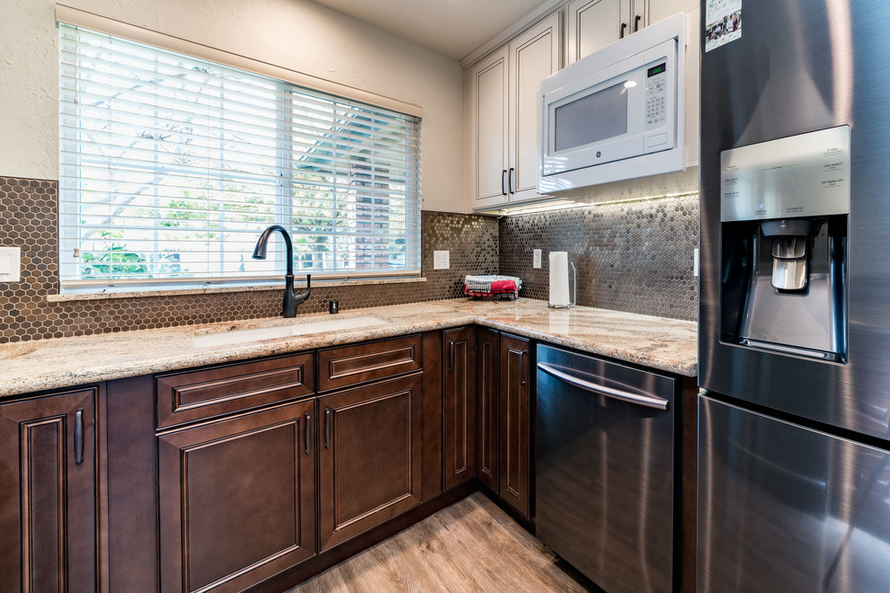 Mid-sized transitional u-shaped medium tone wood floor and brown floor eat-in kitchen photo with an undermount sink, recessed-panel cabinets, white cabinets, granite countertops, brown backsplash, mosaic tile backsplash, stainless steel appliances and no island