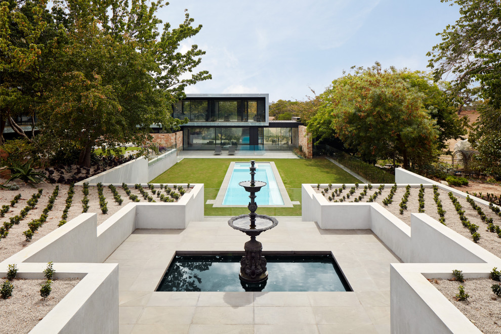 Large modern backyard rectangular lap pool in Melbourne with with a pool and concrete pavers.