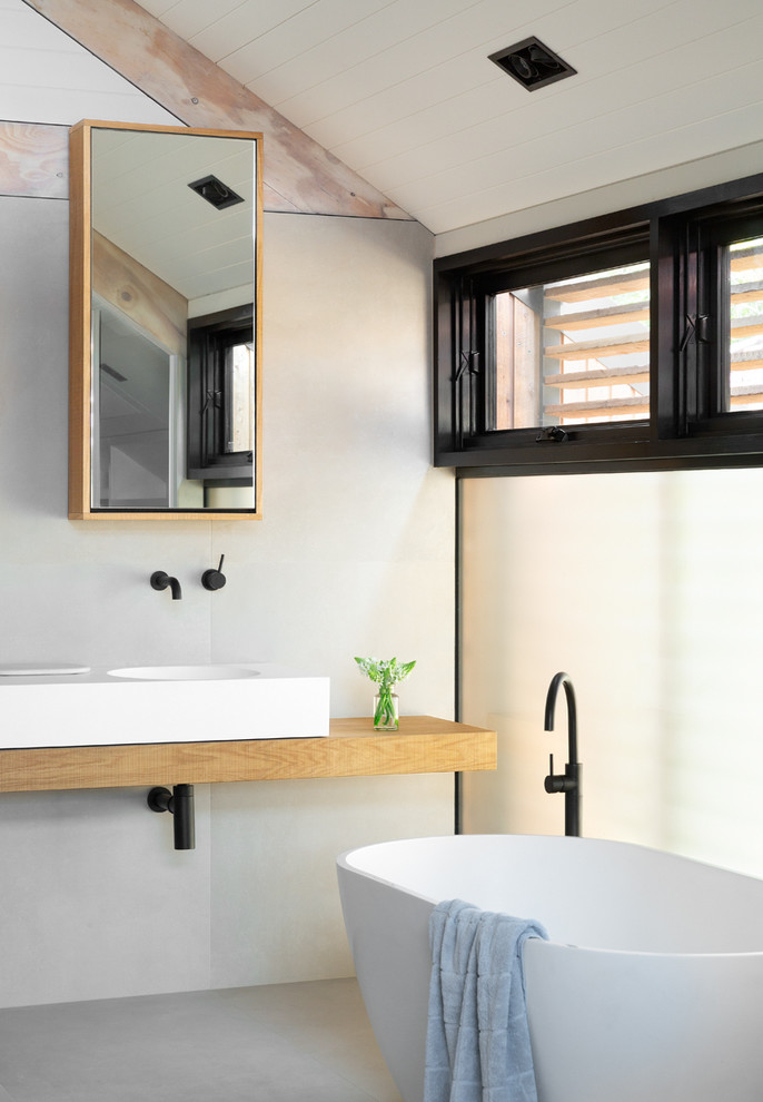 Design ideas for a small contemporary 3/4 bathroom in Melbourne with glass-front cabinets, a freestanding tub, an open shower, white walls, a wall-mount sink, wood benchtops, an open shower and brown benchtops.