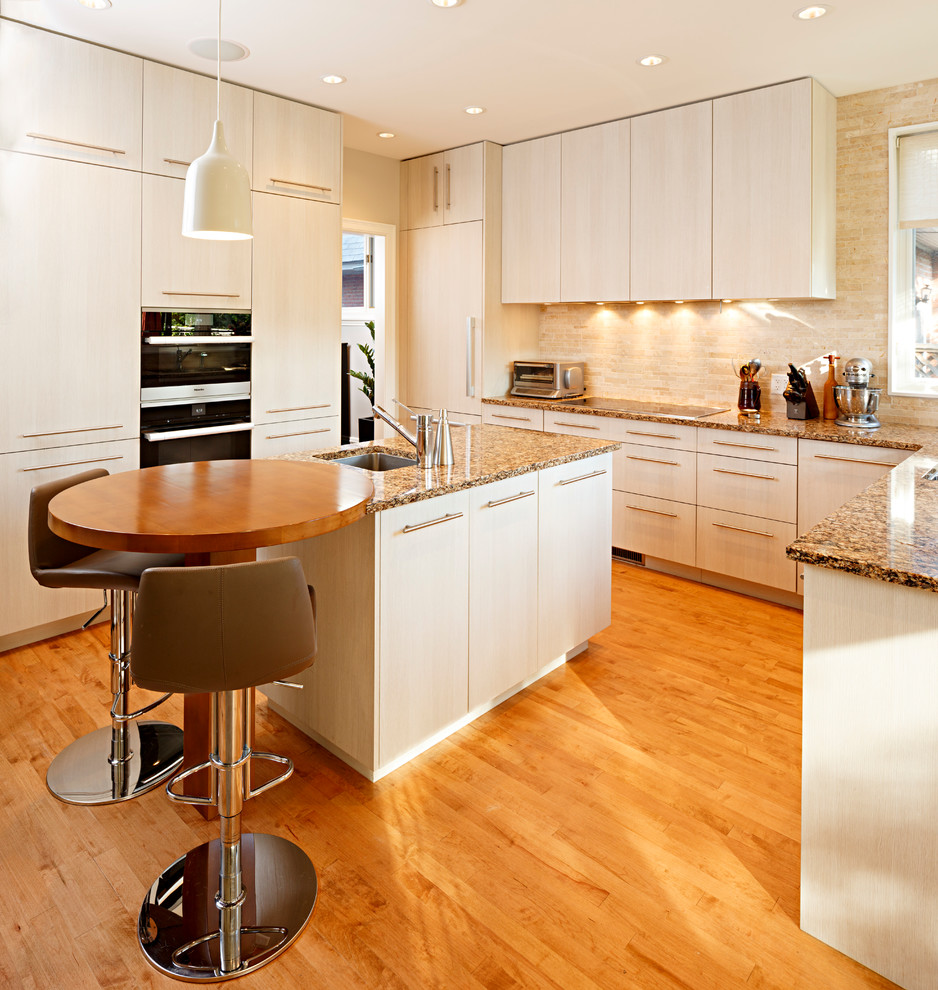 Example of a mid-sized transitional l-shaped medium tone wood floor and brown floor eat-in kitchen design in Ottawa with a single-bowl sink, flat-panel cabinets, beige cabinets, granite countertops, beige backsplash, stone tile backsplash, stainless steel appliances and an island