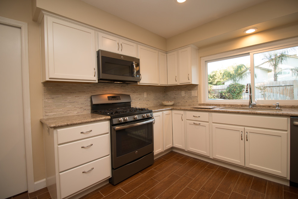 Example of a mid-sized transitional u-shaped porcelain tile open concept kitchen design with an undermount sink, recessed-panel cabinets, beige cabinets, quartz countertops, beige backsplash, mosaic tile backsplash and colored appliances