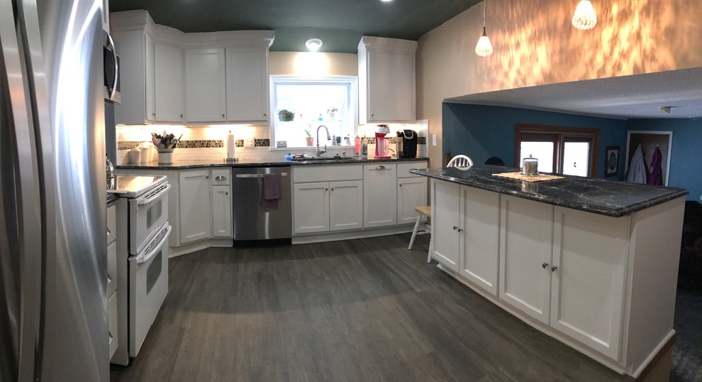Eat-in kitchen - mid-sized transitional u-shaped medium tone wood floor eat-in kitchen idea in New York with a double-bowl sink, shaker cabinets, white cabinets, granite countertops, white backsplash, subway tile backsplash and stainless steel appliances