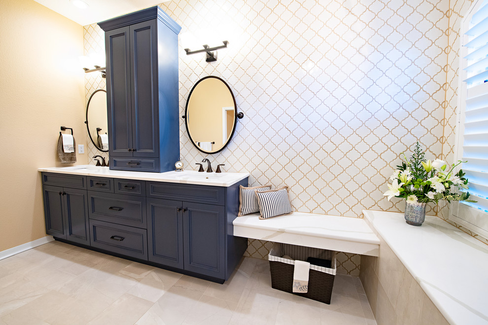 Inspiration for a mid-sized transitional master bathroom in Tampa with flat-panel cabinets, blue cabinets, a curbless shower, a one-piece toilet, beige tile, porcelain tile, yellow walls, porcelain floors, an undermount sink, engineered quartz benchtops, beige floor, an open shower and white benchtops.