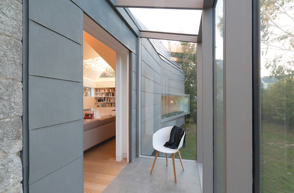 This is an example of a mid-sized contemporary sunroom in Paris with ceramic floors, no fireplace and a glass ceiling.