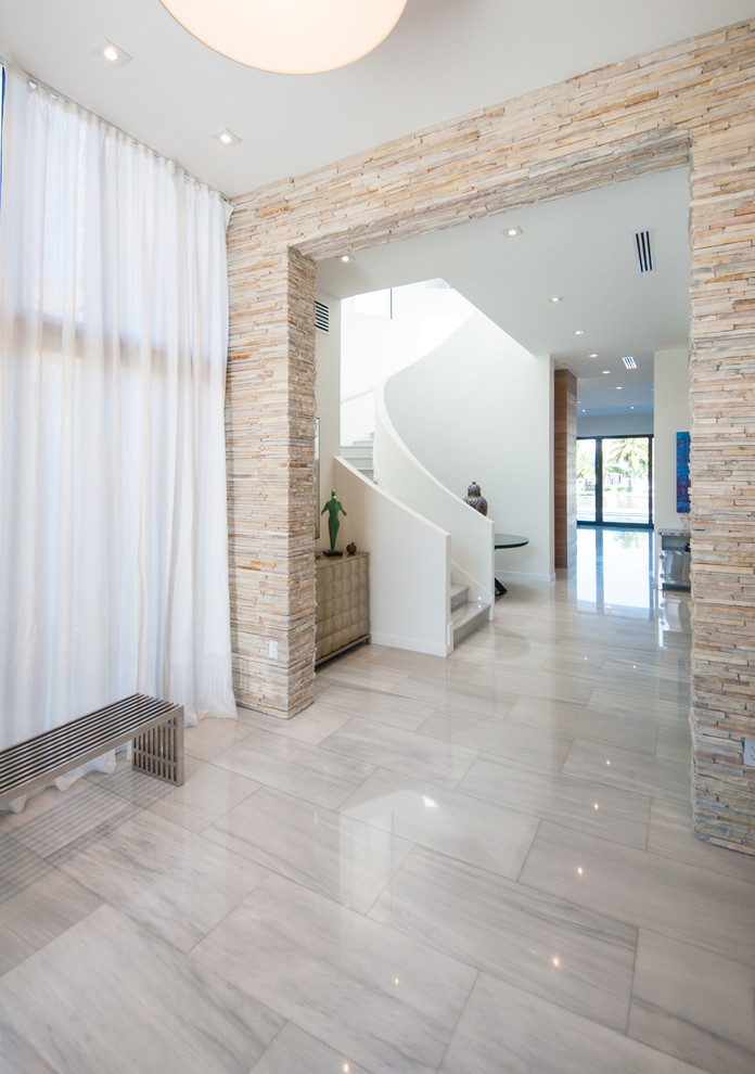 Photo of a contemporary hallway in Miami with white walls, marble floors and beige floor.