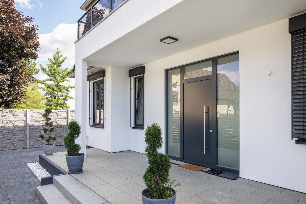 Mittelgroße Moderne Haustür mit weißer Wandfarbe, Backsteinboden, Einzeltür, Haustür aus Metall, grauem Boden und Treppe in Berlin