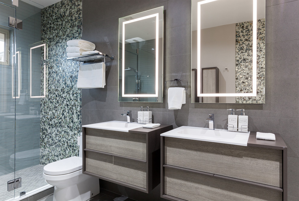 This is an example of a mid-sized contemporary master bathroom in Dallas with flat-panel cabinets, grey cabinets, an alcove shower, a one-piece toilet, gray tile, white tile, pebble tile, grey walls, porcelain floors, a drop-in sink and concrete benchtops.