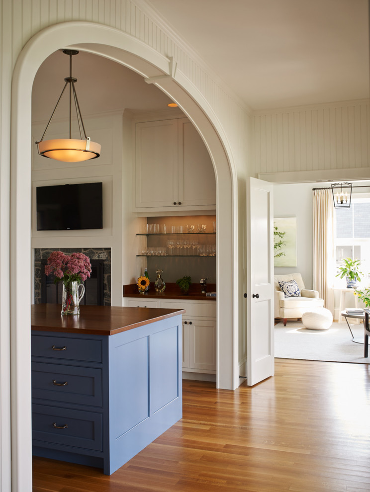 Design ideas for a small traditional single-wall wet bar in Portland Maine with an undermount sink, shaker cabinets, white cabinets, wood benchtops, grey splashback and medium hardwood floors.