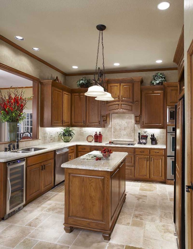 This is an example of a traditional kitchen in Dallas with stainless steel appliances and travertine splashback.
