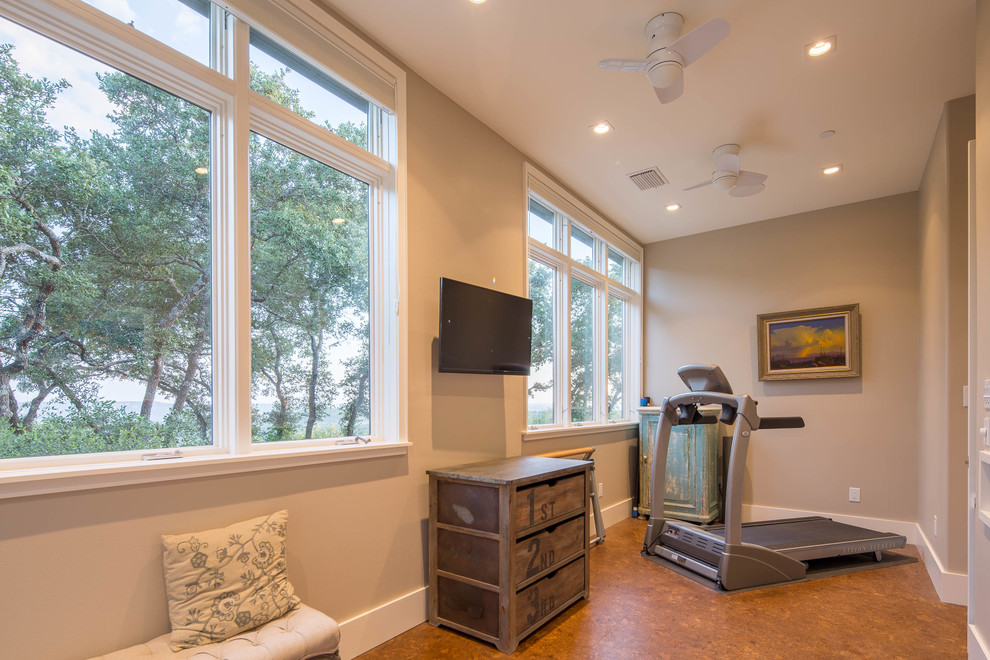 This is an example of a mid-sized modern multipurpose gym in Austin with beige walls, cork floors and brown floor.