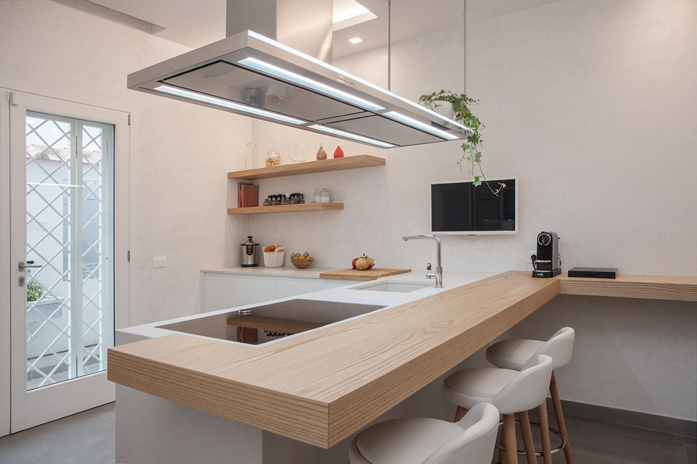 This is an example of a contemporary l-shaped kitchen in Florence with an undermount sink, flat-panel cabinets, white cabinets, a peninsula and white benchtop.