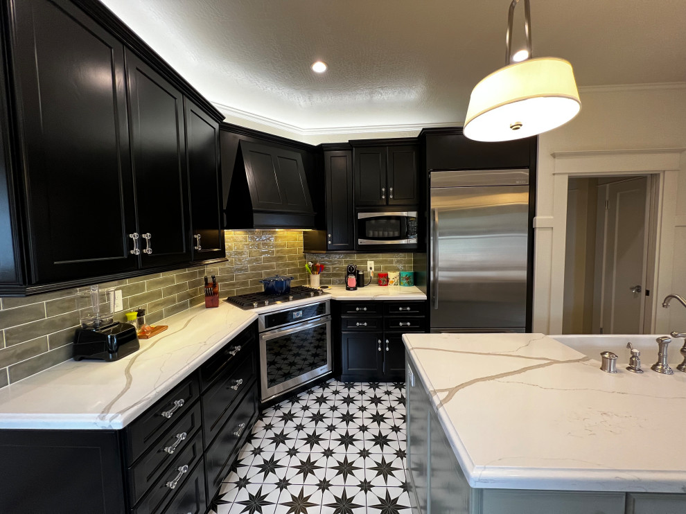Inspiration for a large arts and crafts u-shaped kitchen in San Francisco with a farmhouse sink, flat-panel cabinets, black cabinets, quartz benchtops, green splashback, ceramic splashback, stainless steel appliances, porcelain floors, with island, black floor and white benchtop.