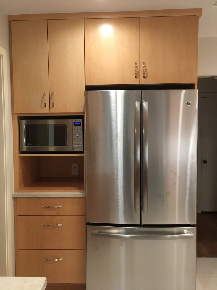 Inspiration for a mid-sized transitional u-shaped porcelain tile and gray floor enclosed kitchen remodel in DC Metro with an undermount sink, flat-panel cabinets, medium tone wood cabinets, quartz countertops, white backsplash, porcelain backsplash, stainless steel appliances and no island