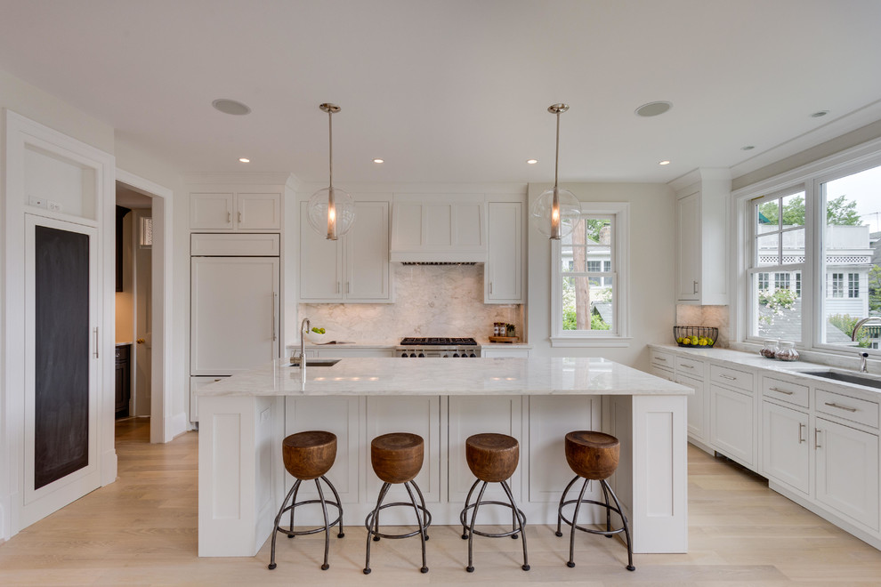 Design ideas for a traditional l-shaped kitchen in DC Metro with an undermount sink, shaker cabinets, white cabinets, white splashback, panelled appliances, light hardwood floors and with island.