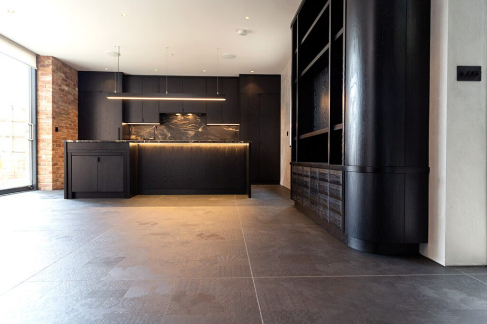 Exempel på ett stort minimalistiskt svart linjärt svart kök och matrum, med en enkel diskho, luckor med profilerade fronter, svarta skåp, bänkskiva i akrylsten, svart stänkskydd, svarta vitvaror, klinkergolv i keramik, en köksö, beiget golv och stänkskydd i marmor