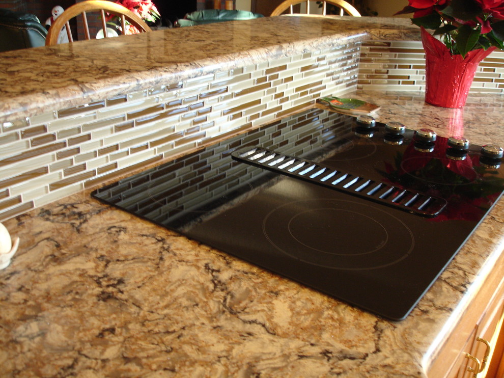 Example of a large transitional l-shaped medium tone wood floor eat-in kitchen design in Seattle with beige backsplash, an island, a single-bowl sink, raised-panel cabinets, medium tone wood cabinets, granite countertops, glass tile backsplash and paneled appliances