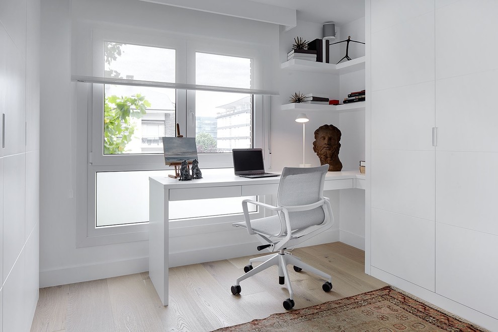 This is an example of a mid-sized contemporary study room in Other with white walls, medium hardwood floors, no fireplace and a built-in desk.
