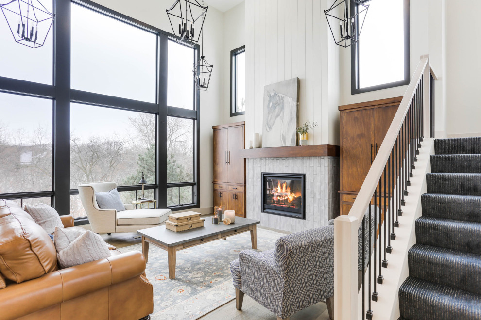 Design ideas for a transitional open concept living room in Minneapolis with white walls, medium hardwood floors, a standard fireplace, a tile fireplace surround, brown floor and planked wall panelling.