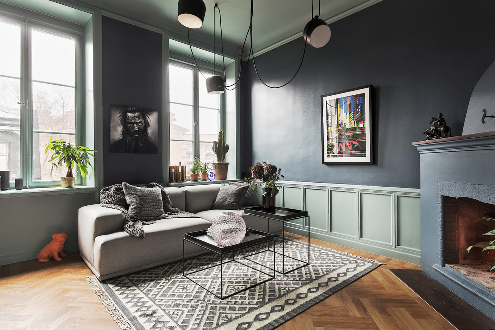 Design ideas for a mid-sized scandinavian formal open concept living room in Stockholm with blue walls, medium hardwood floors, a corner fireplace and no tv.