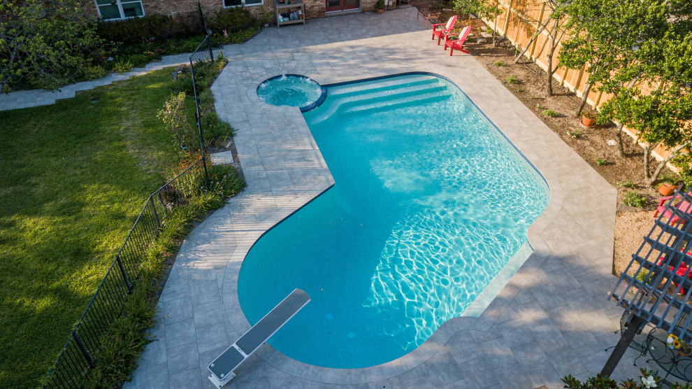 Inspiration for a traditional backyard kidney-shaped pool in Houston with natural stone pavers.