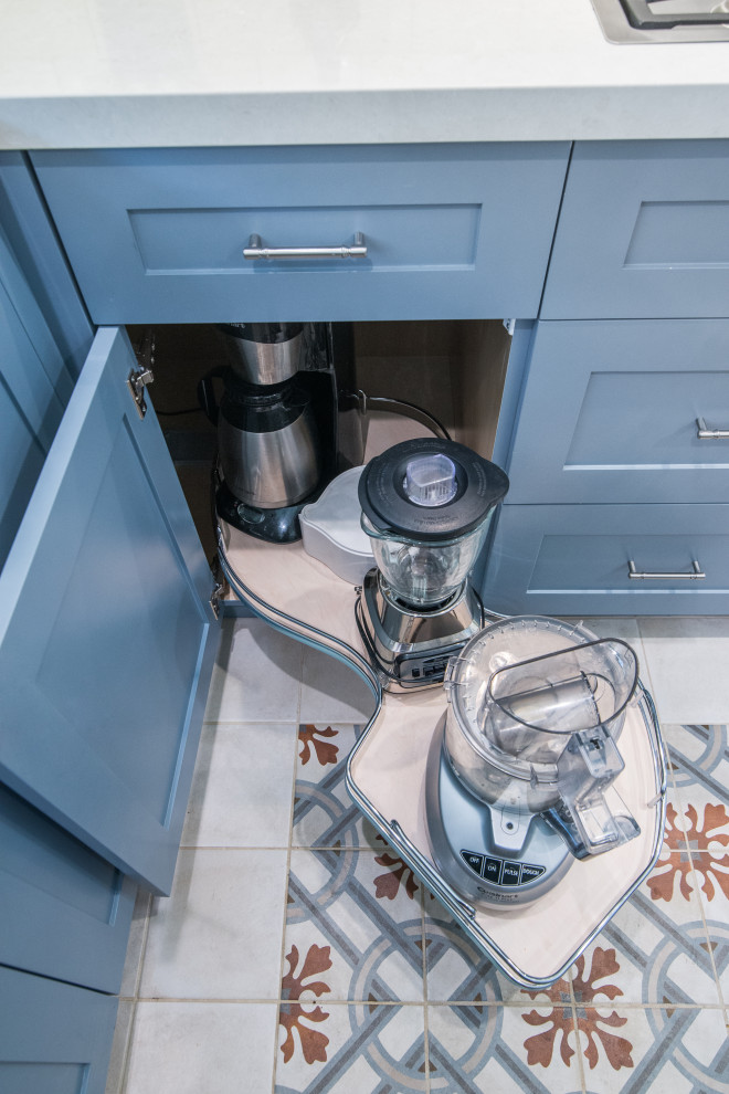 Inspiration for a mid-sized transitional u-shaped ceramic tile and multicolored floor enclosed kitchen remodel with an undermount sink, shaker cabinets, blue cabinets, limestone countertops, white backsplash, subway tile backsplash, stainless steel appliances, a peninsula and white countertops
