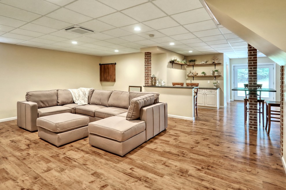 This is an example of a large industrial basement in Other with beige walls and laminate floors.